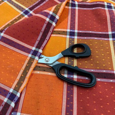 Tessuto a quadrettoni colori caldi con decorazioni a rombi dettaglio forbice 1