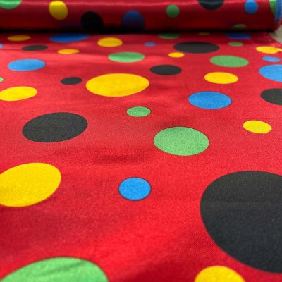 Raso motivo a pois multicolor su sfondo rosso 2