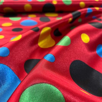 Raso motivo a pois multicolor su sfondo rosso 1