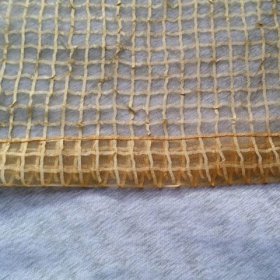 Tessuto per tende in organza a quadrettini color beige disteso 1