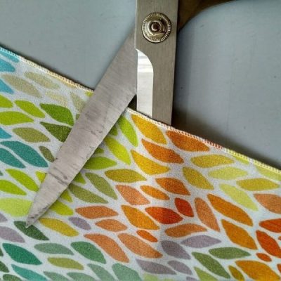 Tessuto per tende crepe effetto seta con fantasia a foglie multicolor bianco dettaglio forbice