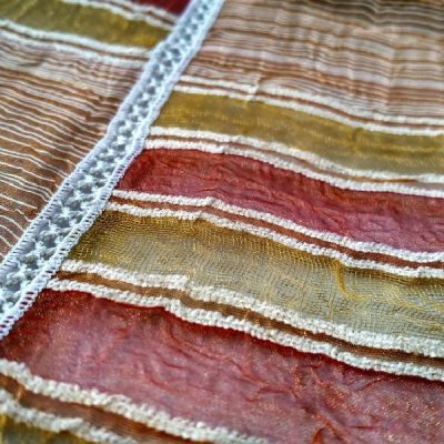 Tessuto per tende a vetro in organza bordato a crochet al metro con quadri e righe multicolore colori caldi dettaglio 2