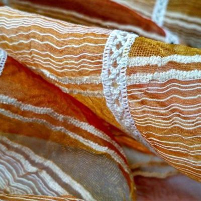 Tessuto per tende a vetro in organza bordato a crochet al metro con quadri e righe multicolore colori caldi dettaglio 1