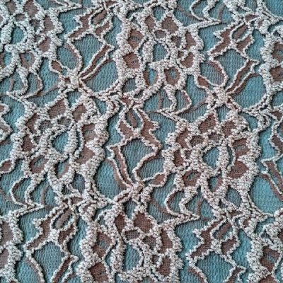 Tessuto in pizzo con rose in rilievo colore grigio freddo al metro