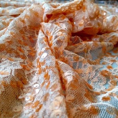 Tessuto in tulle con paillettes motivo floreale arancione arricciato