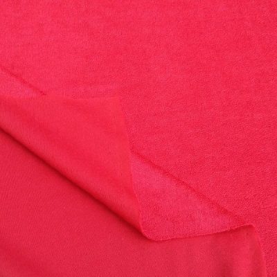 Tessuto in ciniglia cangiante per abiti al metro rosso lampone piegato