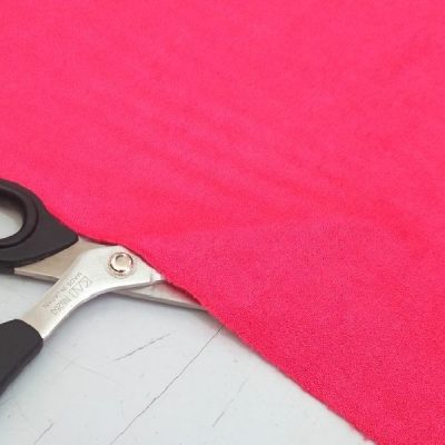 Tessuto in ciniglia cangiante per abiti al metro rosso lampone con forbice