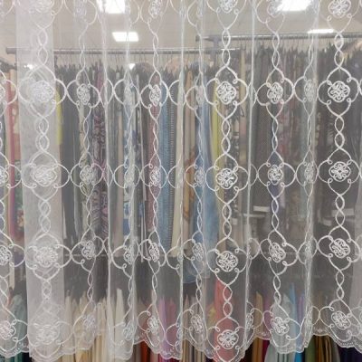 tessuto per tende in tulle ricamato bianco al metro trasparenza appesa con scampoli dietro 1