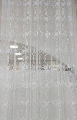 tessuto per tende in tulle ricamato bianco al metro trasparenza appesa con sfondo bianco in lungo 1