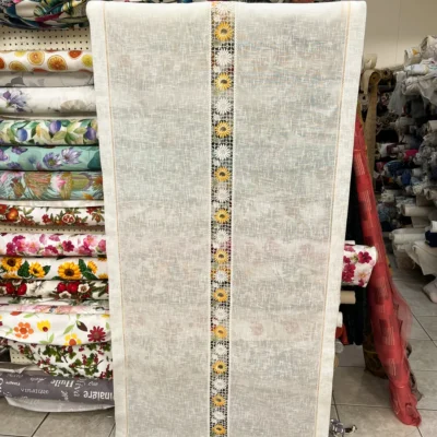 Tendina girasoli country esposta in negozio di tessuti con altri rotoli