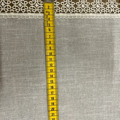 Dettaglio bordo laterale in pizzo macram&egrave; bianco latte su tendina a vetro bianca