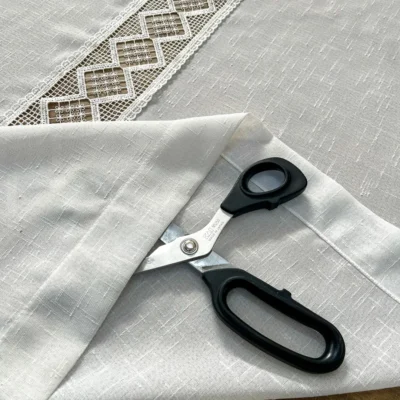 Dettaglio tessuto effetto lino bianco naturale e orlo confezionato della tendina a vetro