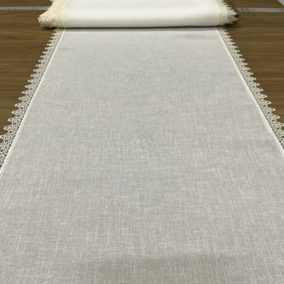 Tessuto tendina effetto lino bianco naturale semitrasparente con bordo pizzo macram&egrave;, steso su banco