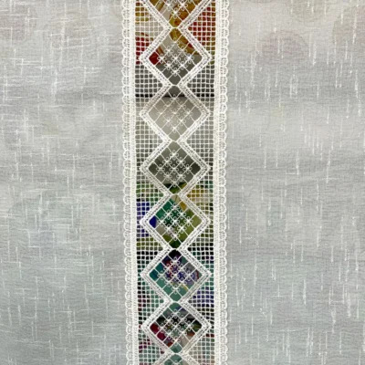 Fascia centrale traforata a rombi vista controluce su tendina effetto lino bianco