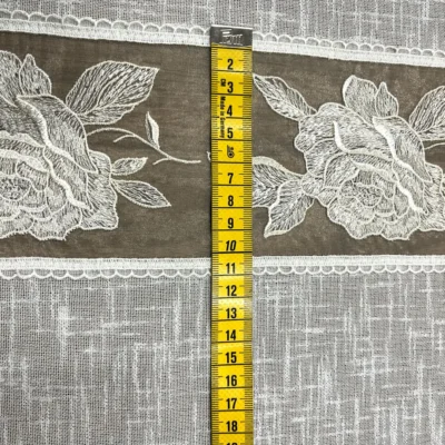 Dettaglio fascia decorativa tortora con rose ricamate bianco latte su tendina a vetro