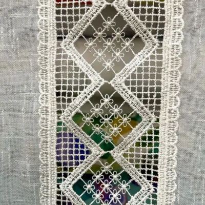 Dettaglio fascia centrale traforata con motivo a rombi e piccoli fiori ricamati bianco latte