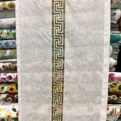 Primo piano motivo geometrico meandro greco ricamato bianco su tortora