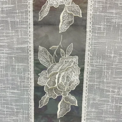 Dettaglio ricamo rose bianco latte su fascia centrale tortora della tendina a vetro