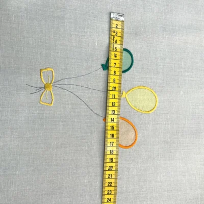 Dettaglio della lavorazione a punto a giorno sul bordo della tendina a vetro bianca per cameretta.